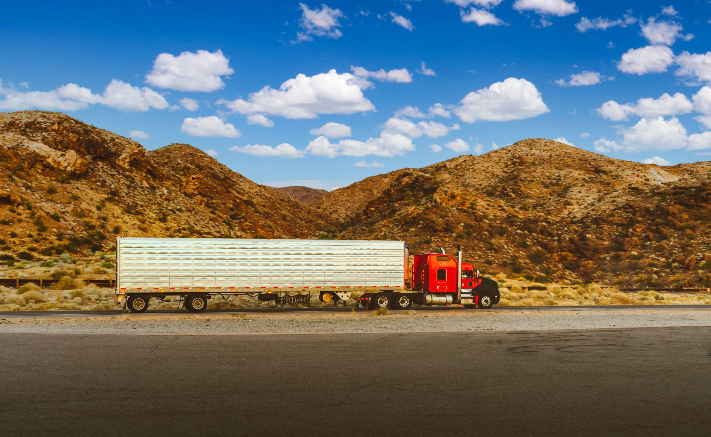 Red semi-truck traveling on an open highway